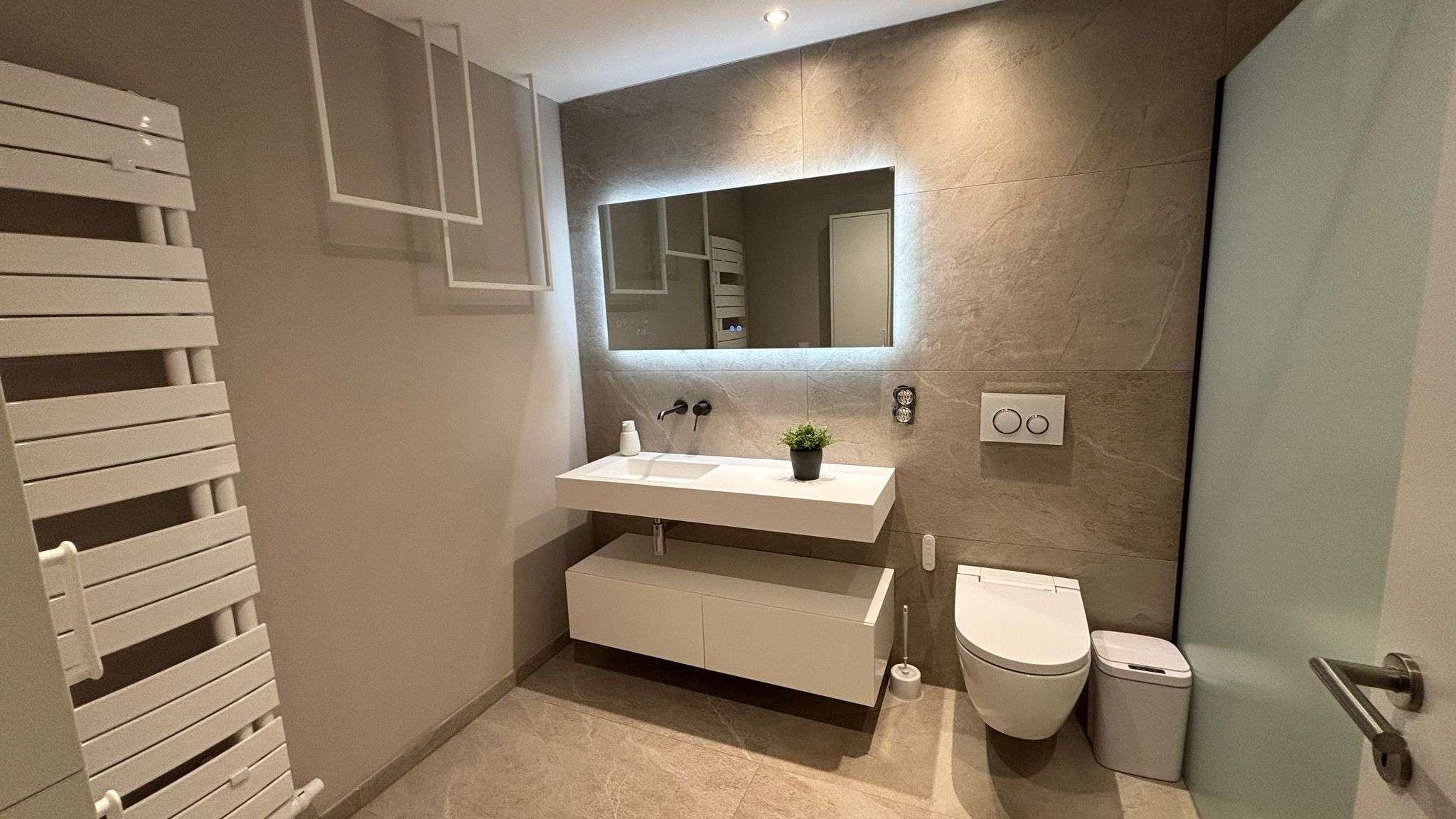 Bad in Marmoroptik greige mit Walk-in-Dusche und großformatigen Wandfliesen