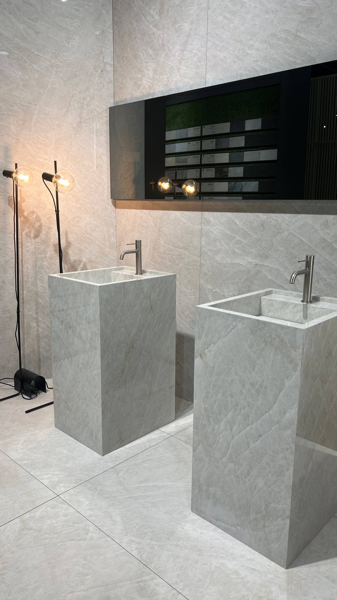 Musterdisplay mit Säulen-Waschtischen und großformatigen Platten im Showroom