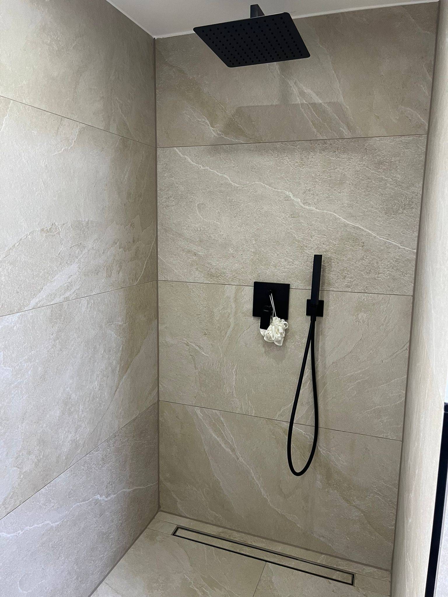 Walk-in-Dusche in Steinoptik mit Gefälleschnitt zur Linienrinne